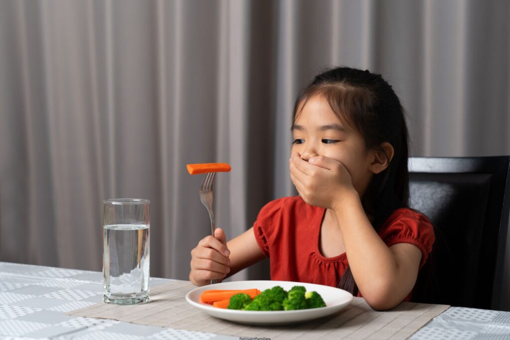 Little cute kid girl refusing to eat healthy vegetables