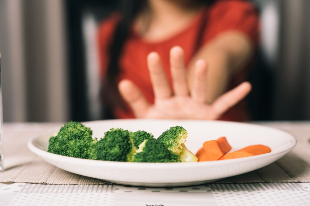 Little cute kid girl refusing to eat healthy vegetables