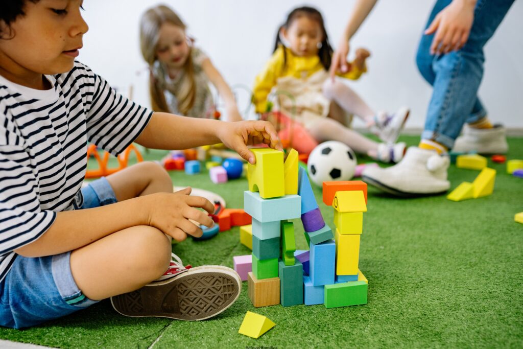 Girl in White and Black Striped Shirt Playing Lego Blocks