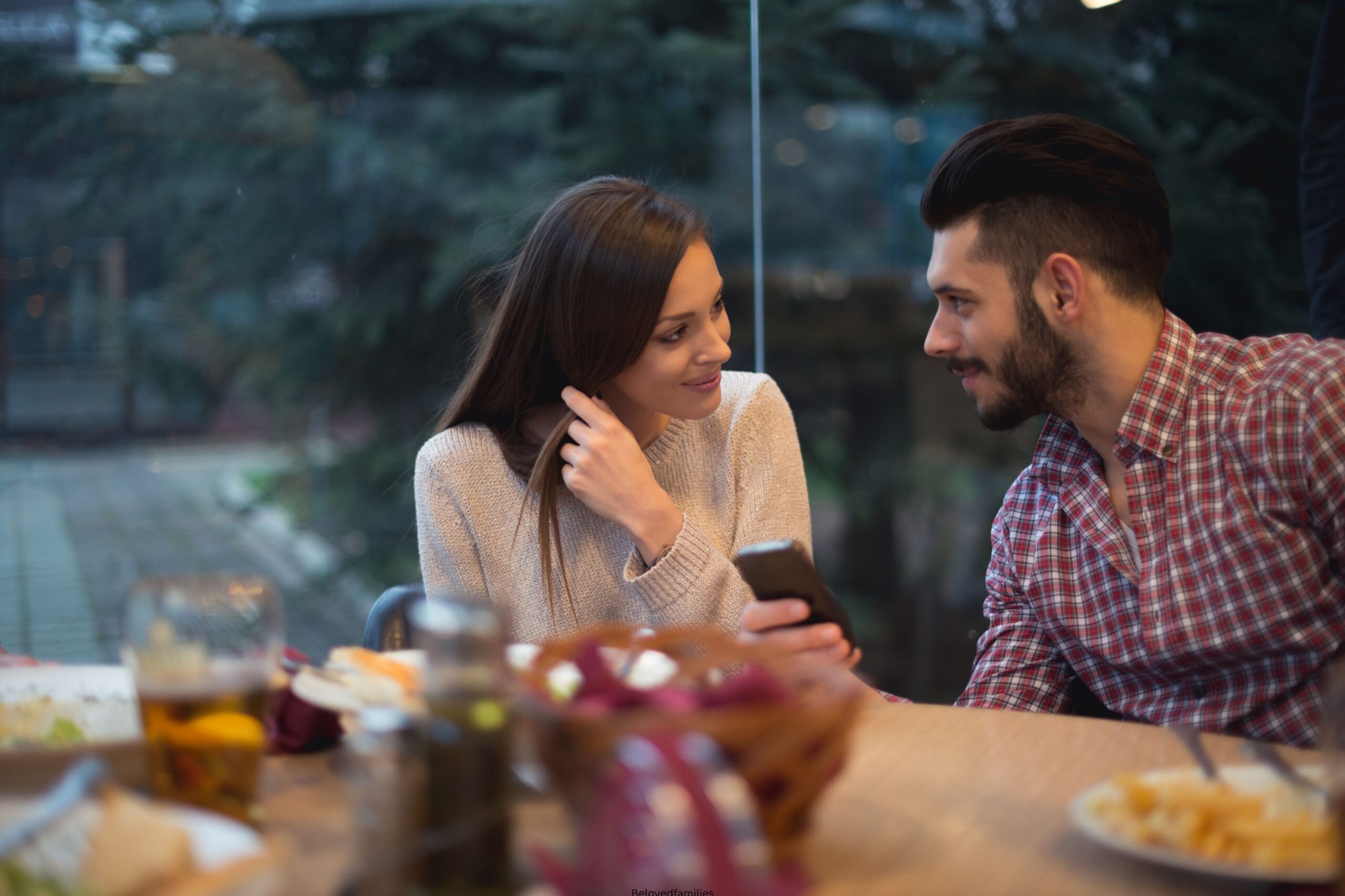 Happy couple sitting at table in cafe during date